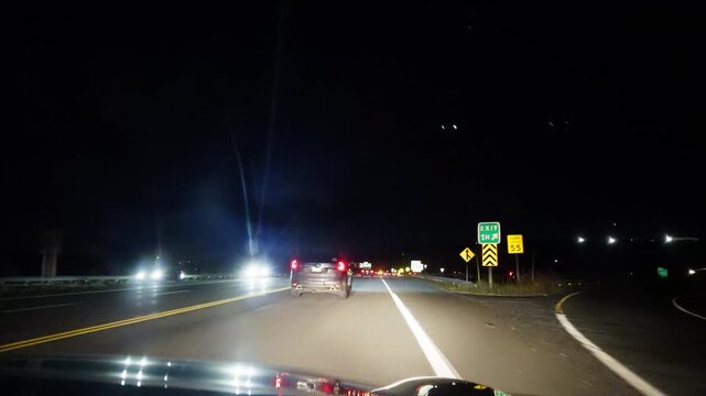 First-person view through windshield: high-speed night driving on rural highway near Halifax. Headlights illuminate summer road, oncoming lights streak, warm Canadian night 4K.