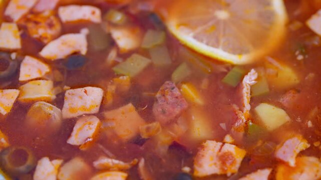 Rich tomato broth with smoked ingredients, Hearty smoked meat and vegetable stew with vibrant colors, Flavorful smoky solyanka soup featuring lemon slice and rustic presentation