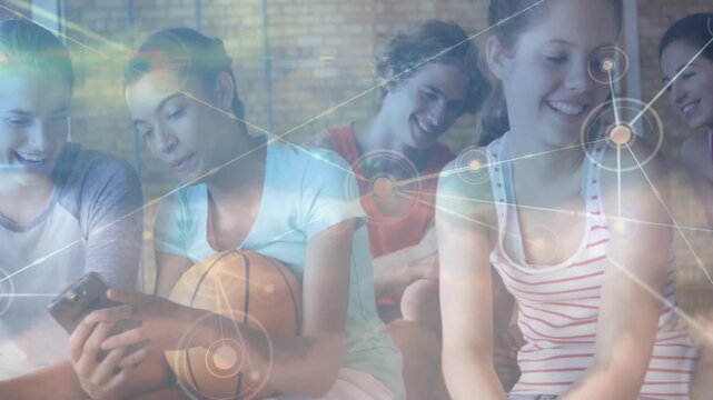 Girl holding basketball turning phone on bench, sharing sports clip, overlay fading across group