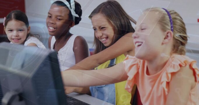 Four girls typing one reaching monitor peers leaning and pointing, sharing discovery in education