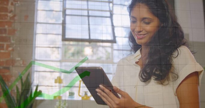 Female worker tapping tablet in loft, initiating grid and rising green finance graph, analyzing