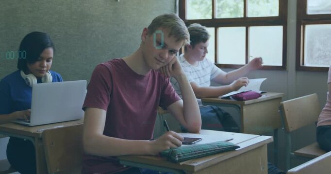 Tapping smartphone, teen male student wearing maroon tee raising head toward camera at front desk