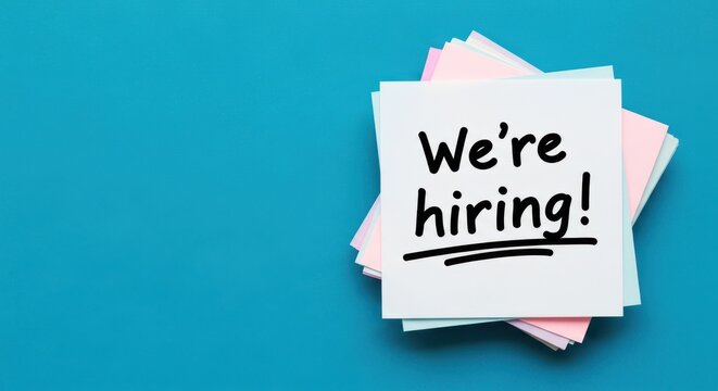 We're Hiring! handwritten text on white sticky notes stack on a vibrant blue background, recruitment concept