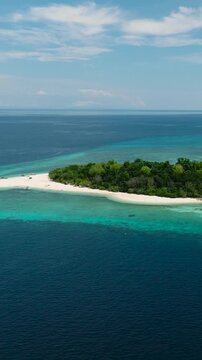 Turquoise water and blue sea on Mantigue Island with white beach and sandbar. Camiguin, Philippines. Vertical video.