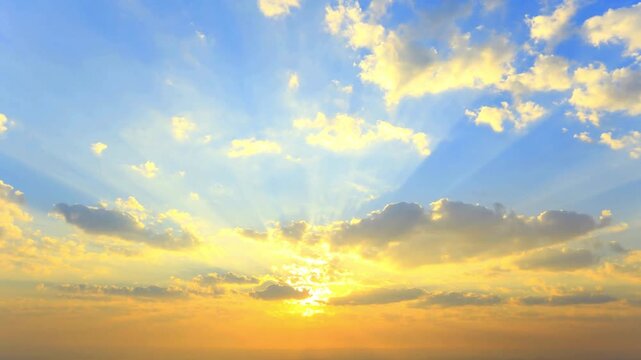 Golden sunrise beams through clouds painting sky with vibrant hues and warm light