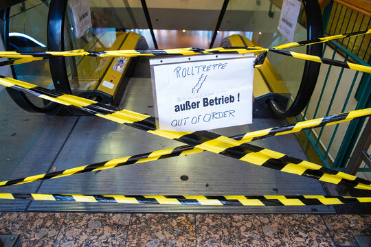 Mit gelb-schwarzem Absperrband gesicherte Rolltreppe, handgeschriebenes Schild &bdquo;Rolltreppe au&szlig;er Betrieb &ndash; Out of order&ldquo;, Berlin, Deutschland