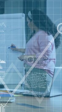 Vertical video: Woman picking up marker drawing business graph at flipchart with HUD matching graph