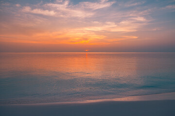Obraz premium Deep orange sunset over calm ocean horizon, soft gradient sky, serene seascape, peaceful nature background, summer travel atmosphere