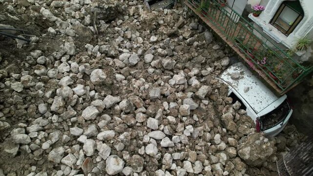 A landslide and collapse, an environmental disaster and destruction. The historic fortress wall collapsed during heavy and prolonged rains. Rocks, mud, and debris completely buried parked cars.