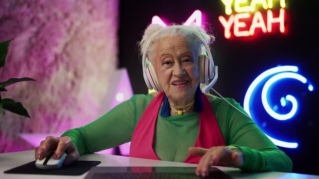 POV of stylish granny playing video game on laptop, celebrating big win