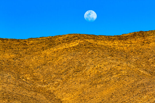 Background. A full moon rising above a tall desert dune. Sahara, Djanet, Algeria, Africa

