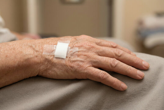 Close-up of a senior hand with adhesive bandage after injection or IV treatment, symbolizing healthcare, recovery, medical care, and elderly wellness.