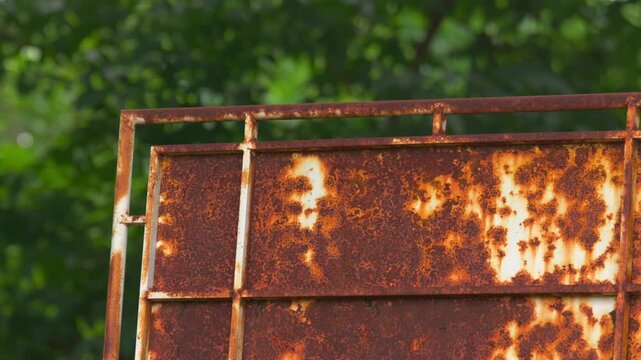 Close-Up of Rusty Metal Sign with Green Background