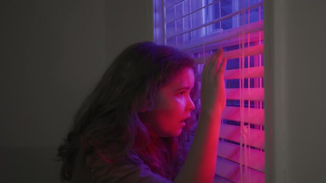 Threat WITH child during police siren night. Threat makes afraid kid worry. Threat through flashing police lights outside. Threat child near crime scene.