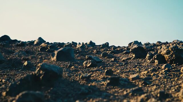 Barren planetary surface stretching into the distance under a clear sky, featuring rocky terrain and dark igneous rocks, evoking themes of space exploration and a desolate environment