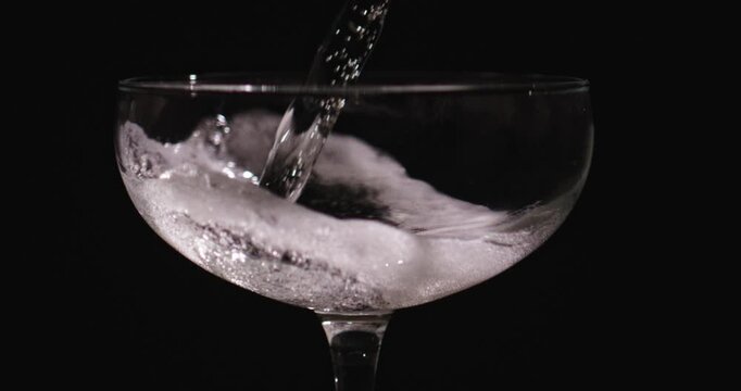 Champagne bubbles shimmering brightly in slow motion. Champagne prosecco pouring creates slow motion effect. Champagne wine glass capturing bubbles in slow motion. Champagne sparkling wine.