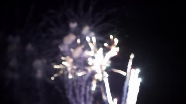 A majestic fireworks display in stunning slow-motion against a starless night sky, featuring shimmering gold trails, cerulean blue starbursts, and ruby red cascades, with anamorphic flares. Visual