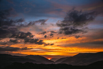 Obraz premium Fiery sunset over layered mountain silhouettes in the Peruvian Andes