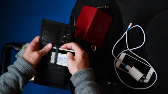 Maleta, empacar y preparativo viaje con pasaporte, tarjeta, dinero y tel&eacute;fono m&oacute;vil con cargador
