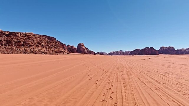 View from car Driving Through Wadi Rum know as Valley of the Moon or Red Mountains. Sandstone and granite rock in southern Jordan near border with Saudi Arabia.