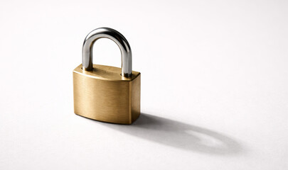 Fototapeta premium Closed brass padlock with shadow on white background