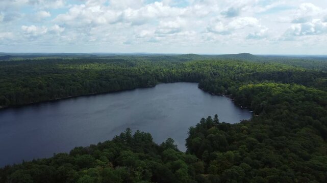 Flying over Buckskin Lake on a late summer afternoon towards the expansive wilderness of crown land located in the Tory Hill area of Highlands East, in southern Ontario, Canada.