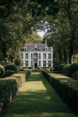 Obraz premium A large white house stands at the end of a long green path lined with bushes and trees during the day, inviting visitors to explore the garden area surrounding it