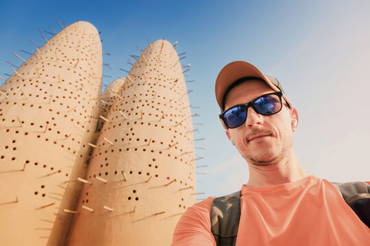 Male tourist capturing a selfie while visiting the intricate traditional mud pigeon towers in Doha, Qatar