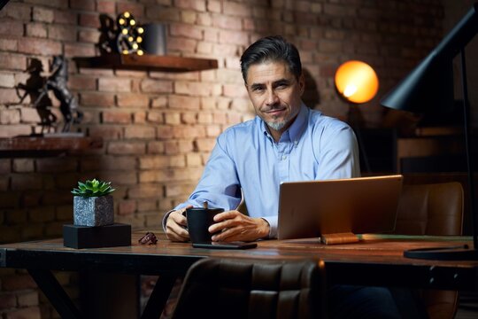 Man working from home in home office with tablet computer at desk in trendy room.