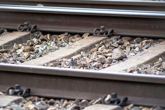Weathered train tracks rest on rugged stones, blending engineering strength with natural texture.