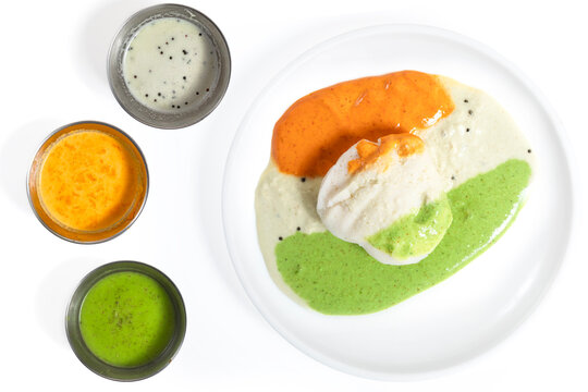 Three varieties of chutney with idli on a white plate, South Indian food