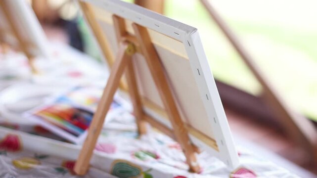Kids drawing at plein air, group class of talented children with painting easel and wooden canvas during lesson of watercolor painting outdoors in summer, art school class for young teen artists