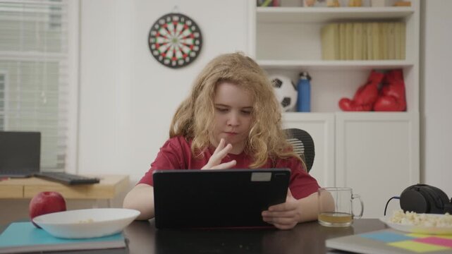 Kid watching gaming content online. Child relaxation while playing game. Kid gamer using tablet to play. Child watching social media on tablet.