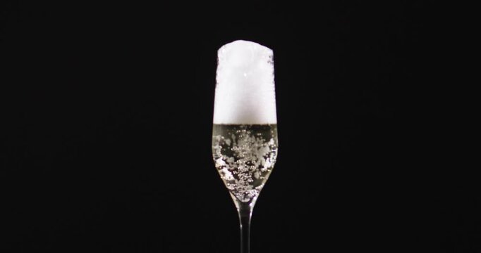 Champagne wine poured into classy glass. Champagne prosecco bubbles rising fast. Champagne glass with pouring wine. Champagne sparkling bubbles in motion.