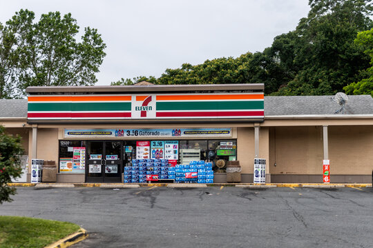 Woodbridge, USA - May 27, 2025: Northern Virginia road near Washington DC with building store shop sign for seven 7-eleven chain brand