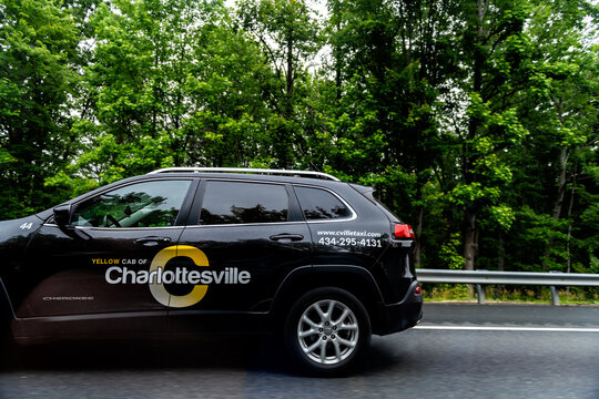 Charlottesville, USA - May 27, 2025: Yellow cab of Charlottesville car vehicle driving on interstate highway road i-64 in rural countryside Virginia