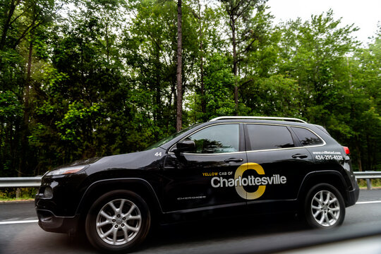 Charlottesville, USA - May 27, 2025: Yellow cab of Charlottesville car vehicle ride driving on interstate highway road i-64 in rural Virginia