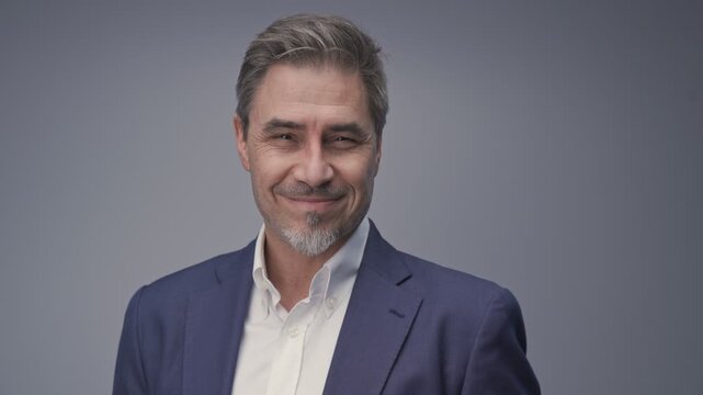 Business portrait - businessman smiling, jacket and open collar white shirt. Mature age, middle age, mid adult man in 50s with gray hair and happy confident smile. Copy space.