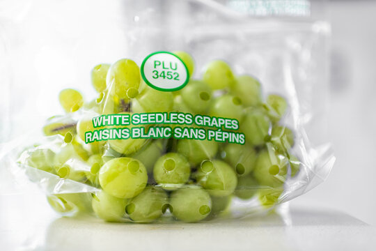 Roseland, USA - February 13, 2025: Green white seedless table grape hybrid grapes fresh fruit berry in plastic bag macro closeup with plu number