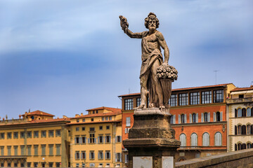 Fototapeta premium Statue of Fall, Bacchus with grapes on Santa Trinita bridge in Florence, Italy