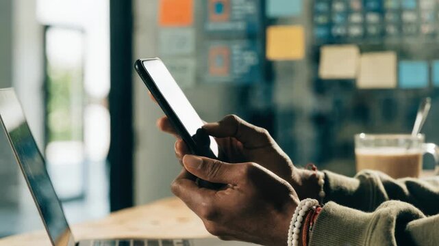Hybrid work setup featuring a consultants hands adjusting settings on a mobile device with blurred digital charts and notes hinting at customizable connectivity options.