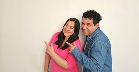 Naklejka premium Latino man and woman in their 40s show their love to celebrate Valentine's Day and their anniversary with kisses and hugs, laughing and smiling