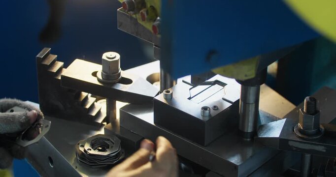 Close-up of stamping die forming metal part at press machine. Precision metalworking and factory production