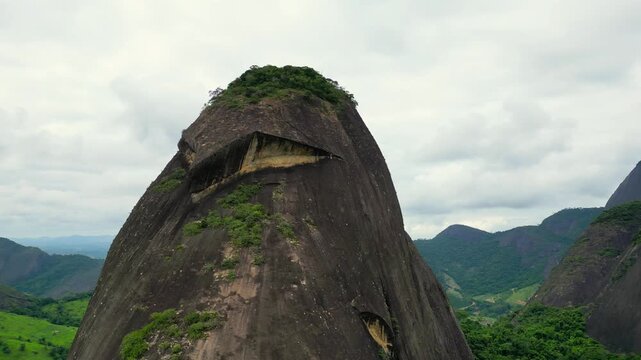 Aerial view of "Pedra da Coruja", a striking inselberg formation in the rural area of Aguia Branca/ES, Brazil. This massive granite outcrop resembles the shape of an owl, standing out in the landscape