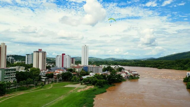 Aerial drone flyover of the city of Governador Valadares, Minas Gerais, Brazil, located along the banks of the Doce river. The footage captures the cityscape, surrounding riverfront, and key landmarks