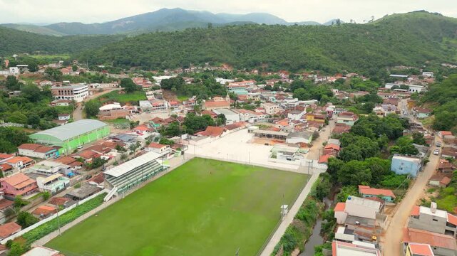 Aerial drone flyover of the city of Divino das Laranjeiras in Minas Gerais, Brazil. The footage captures the urban layout, surrounding countryside, and key landmarks of this small town