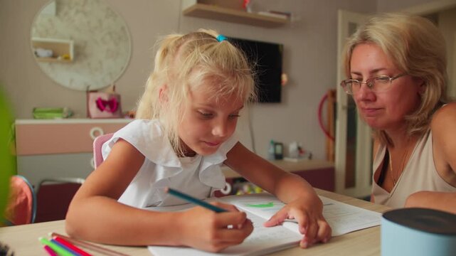 Home learning scene with preschool child and mother. Preparing for school by practicing basic academic skills