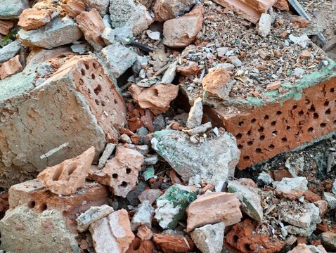 Ruined bricks scatter urban area. Collapse aftermath with debris and green moss present everywhere