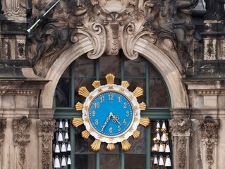 Decorative city clock. Sculpted bells and carved stonework enhancing civic architectural heritage © Vladimir