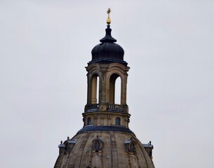 Dome towers skyward. Old majestic tower with detailed stonework and atmospheric city surroundings © Vladimir
